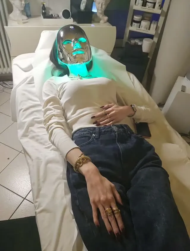 Cliente sdraiata in cabina con la maschera LED accesa di verde